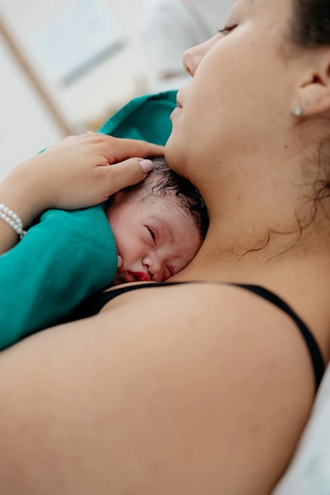 Bebê recém-nascido no colo da mãe, pele com pele