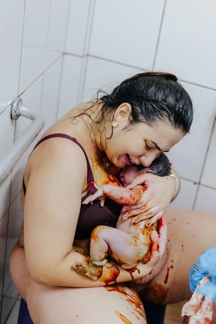 Mãe abraça o bebê logo depois do parto, no primeiro encontro dos dois